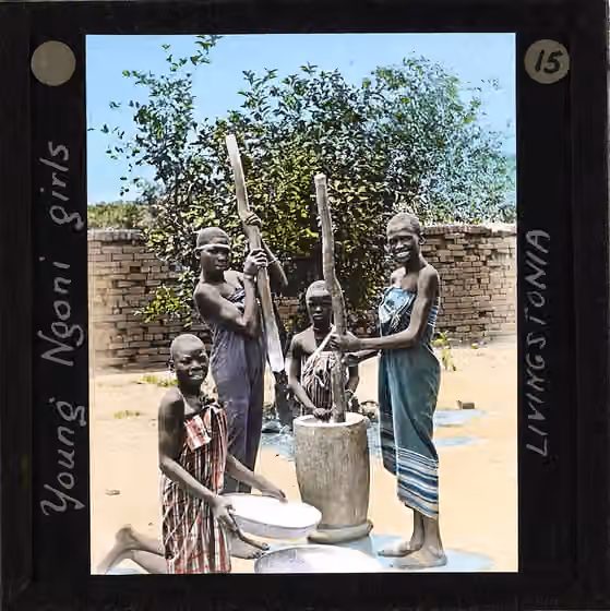 Ngoni people — "Young Ngoni girls, Livingstonia", Malawi, ca.1910 Photograph of 4 young Ngoni girls grinding flour in a large mortar and pestle.