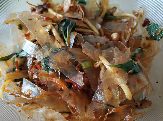 Bánh tráng trộn — The most favorite snack from Vietnam: rice paper is mixed with green mango, dried beef, dried squid, quail eggs and laksa leave