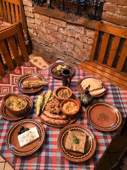 Masakan Eropa — Традиционална македонска трпеза: селско лепче, макало, пинџур, лути пиперки со магдонос, чварки, домашни колбаси, овчо сирење со маслинки, пивтија, сармички со лозов лист и тавче гравче.
