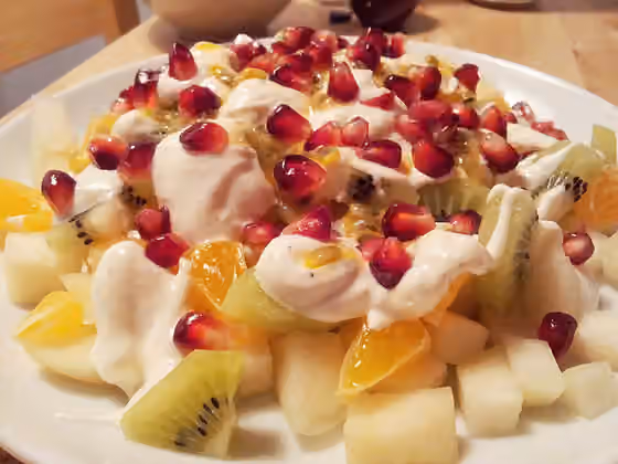 Macedonia — Fruit salad made of pear, satsuma mandarin, kiwifruit, passion fruit, pomegranate seeds, and Greek yogurt mixed with honey, cardamom and vanilla sugar.