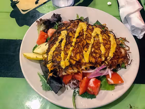 Floribbean cuisine — Sweet Potato Crusted Salmon on Salad with Ranch Style Dressing.