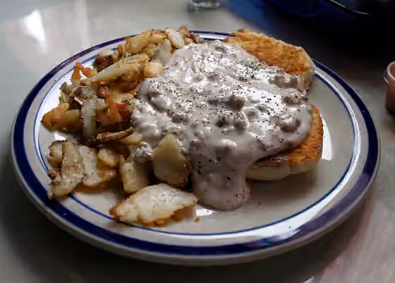 Biskuit dan saus — Picture of Biscuits and gravy , with a side order of home fries.