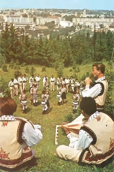 Musik di Rumania — Postcard depicting a group of Romanian folk musicians and dancers dressed in traditional costumes in the Youth Park (Parcul Tineretului), Suceava (the postcard dates to communist times, photograph by Ion Petcu)