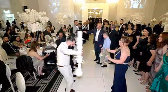Assyrian folk dance — Assyrian wedding circle dance with head of khigga (circle dance) holding a cane (qopala).