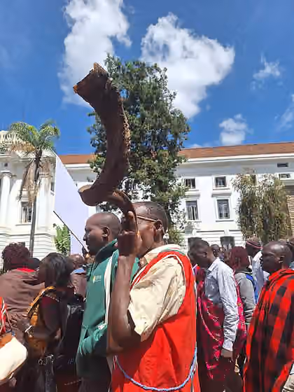 Okiek people — An African man from the Ogiek community in Kenya blowing a horn during a procession in Nairobi
