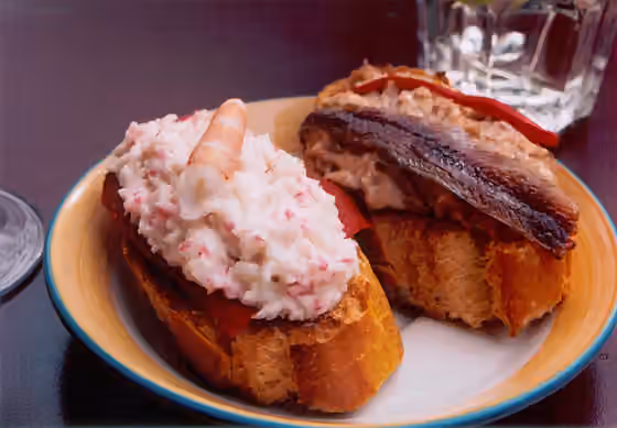 Basque cuisine — Plato con dos pinchos: txaka (cangrejo/surimi) y gamba (izquierda), bonito y anchoa (derecha), ambos con pimientos rojos, servidos en Vitoria-Gasteiz (País Vasco).