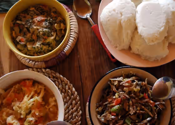Malawian cuisine — Nshima (top right corner) with three relishes.