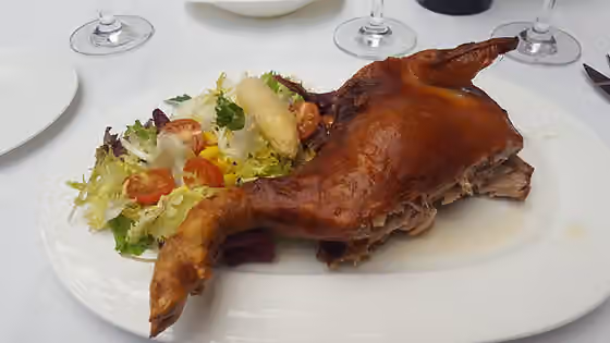 Castilian-Leonese cuisine — Cochinillo (roast pig) ration in the restaurant of the Hotel Palacio de los Velada, Ávila, Spain
