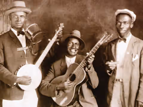 Skiffle — Jug Band Cannon's Jug Stompers (from left to right : Gus Cannon, banjo and jug, Ashley Thompson, guitar and Noah Lewis, harmonica)