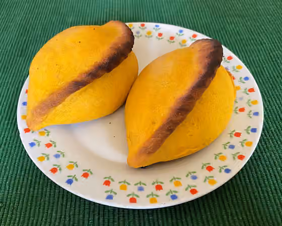 Salteña — Salteñas, a Bolivian empanada filled with beef or chicken, mixed in a sweet, lightly spicy sauce and containing chopped potatoes, raisins and hard eggs.