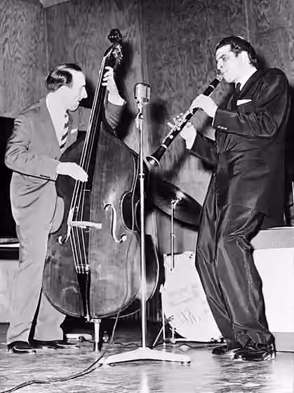 Modal jazz — Photograph of the musicians Erik Lindström (1922–2015) and Tony Scott (1921–2007) performing at the main hall of Helsinki School of Economics.