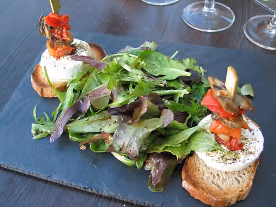 Mesclun — Mesclun, petits légumes marinés et chèvre chaud aux herbes sur toasts.