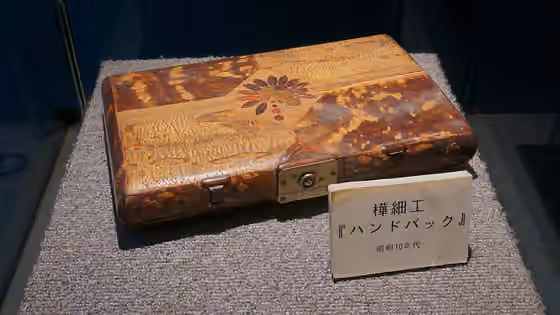 Kabazaiku — 昭和10年代に制作された樺細工のハンドバッグ。なお樺細工とは桜の樹皮を用いるものであり、樺の木は使用しない。このため桜皮細工と表記して「かばざいく」と読むこともある。