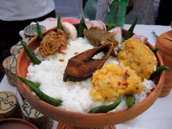 Panta bhat — Panta Ilish - a traditional platter of Panta bhat with fried Ilish slice, supplemented with dried fish (Shutki), pickles (Achar), dal, green chillies and onion - is a popular serving for the Pohela Boishakh festival.