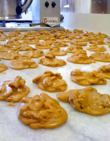 Praline (nut confection) — Freshly hand-scooped pralines from Southern Candymakers and cooling on the marble slab.