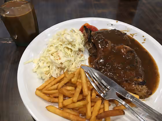Chicken chop — Chicken Chop With French Fries and Coleslaw and a cup of South East Asia thick smokey coffee rich with sweetened condensed milk by the side