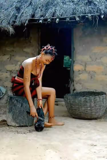 Idoma people — Young Idoma woman dressed with the Idoma colours preparing roasted yam.