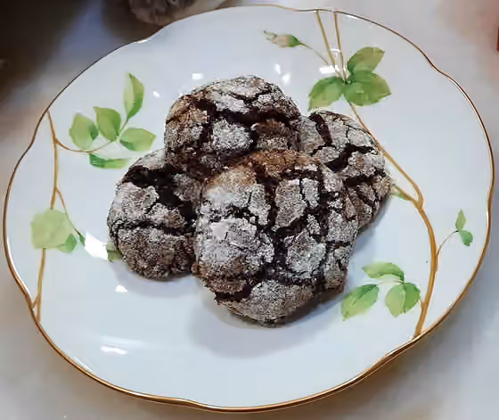 Chocolate crinkle — Pictured above is a plate of chocolate cookies with powdered sugar on top.