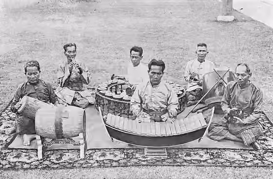 Piphat — A traditional male quintet (plus one additional krap player) of Thailand, consisting of (left to right): Phra Phatbanlengrom (Phim Phimphawathin), playing taphon and klong song na ; Phraya Sanoduriyang (Chaem Sunthonwathin), playing pi ;…