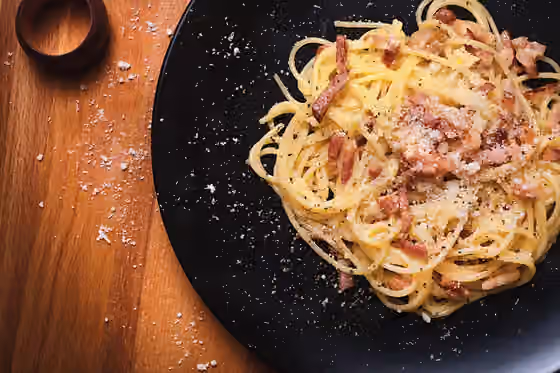 Carbonara — Plato de espaguetis con la salsa carbonara tradicional, hecha a base de huevo, guanciale de cerdo y queso pecorino romano.