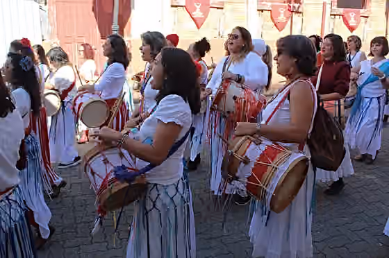 Afoxé (musical tradition) — Grupo busca fazer uma releitura das manifestações populares através da memória das integrantes, da prática, aperfeiçoamento e difusão da arte das Caixas do Divino - tambor pequeno, originário da Festa do Divino do Maranhão.