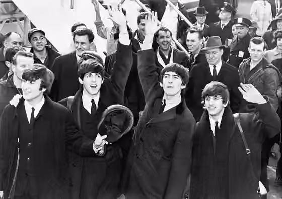 British Invasion — English band The Beatles wave to fans after arriving at John F.
