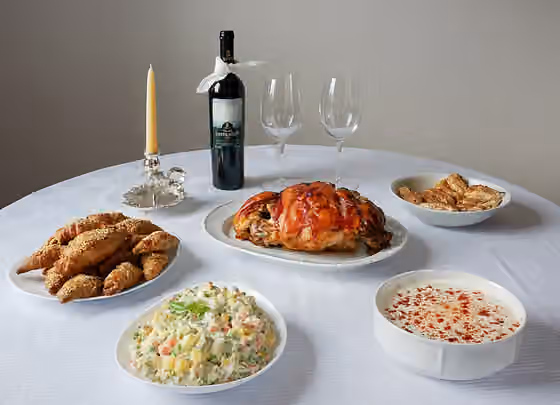 Hidangan Serbia — Christmas table ( Cuisine of Serbia ); grilled pork, Olivier salad (also called Russian salad), tzatziki salad , red wine Vranac , kifli and strudel sweets.