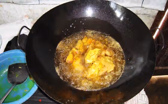 Ayam goreng — Daging ayam yang telah dibumbui sedang digoreng.