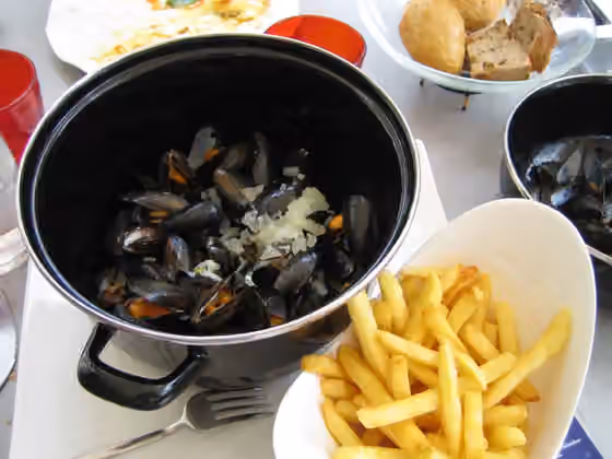 moules-frites — Mussels cooked in broth with fries.