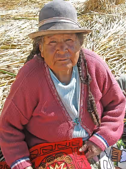 Suku Uru — An elderly woman holding embroidery, Uros Islands, Lake Titicaca, Peru.