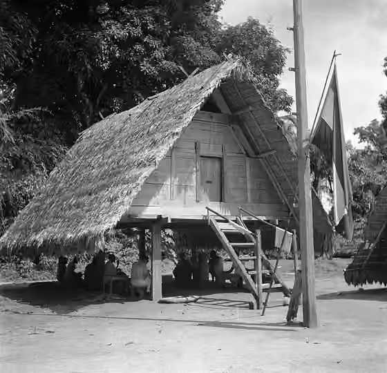 Paramaccan people — Collectie / Archief : Fotocollectie Van de Poll Reportage / Serie : Reis naar Suriname en de Nederlandse Antillen Beschrijving : Bijeenkomst onder een paalwoning in Langetabbetje in Suriname.