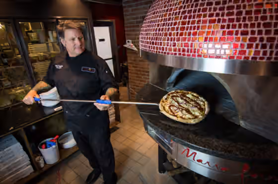 Pizzaiuolo — Glenn using his pizza peel and the Marra Forni oven