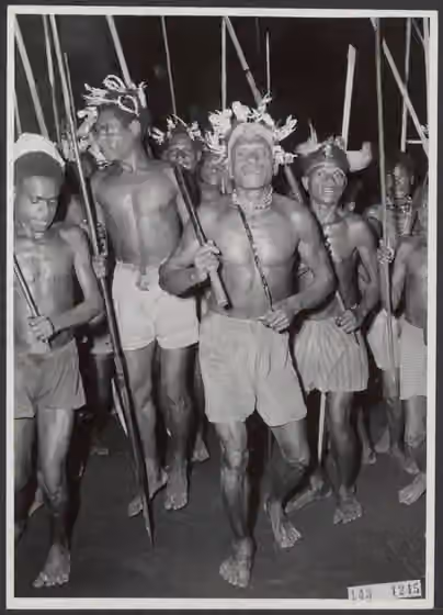 Muyu — Collectie / Archief: Kantoor voor Voorlichting en Radio Omroep Nederlands Nieuw Guinea Beschrijving: Dansende Moejoe-Papoea's in Katan met gevaarlijk uitziende speren (Mappi / Zuid Nieuw-Guinea) Datum: 1955-11 Locatie: Nieuw-Guinea…