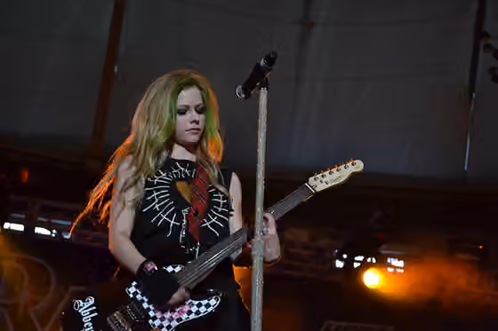 Pop rock — Avril Lavigne playing the guitar on stage during her Black Star Tour on May 27, 2011.