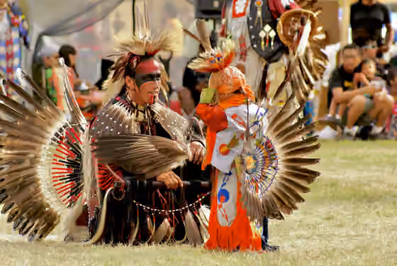 Atikamekw — An Atikamekw child and a male adult in dance regalia at the pow-wow grounds in Manawan, Quebec, Canada
