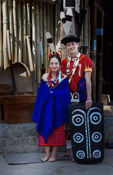 Ao Naga — Wrapped in vibrant Ao tradition, a young couple stands radiant with quiet joy at the Hornbill festival.