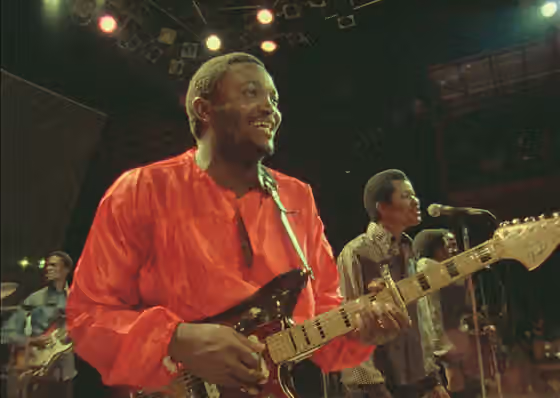 Sebene — Franco Luambo et son orchestre OK Jazz en concert live au Zaïre 74, un festival de musique live sur trois jours qui s'est tenu du 22 au 24 septembre 1974 au Stade du 20 Mai à Kinshasa, Zaïre.