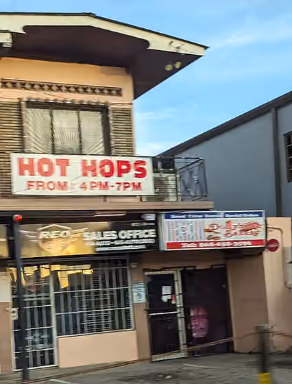 Trinidad and Tobago cuisine — A bakery in El Socorro, Trinidad on the El Socorro main road with a sign for hot hops, hops bread is a type of local bread roll